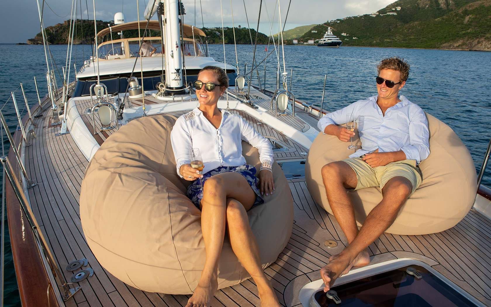 Two People sitting on deck of crewed sailing yacht
