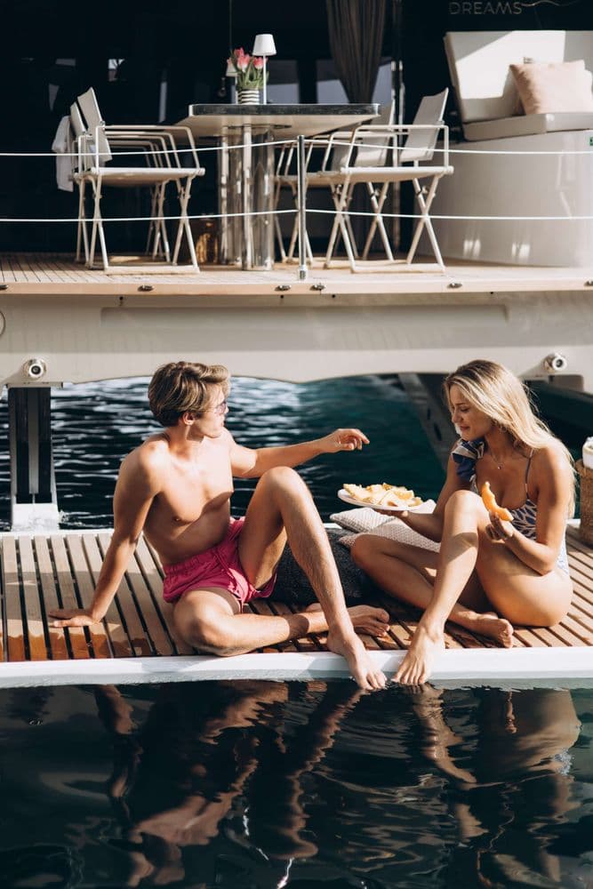 sunreef 50 sweet dreams couple sitting swim platform crewed